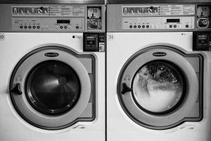 A black and white picture of two dryers in a laundromat