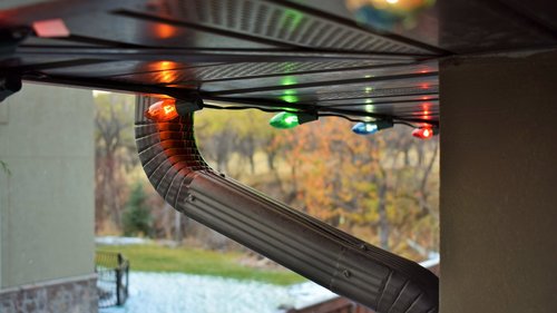 A closeup of Christmas lights properly hung from a roof